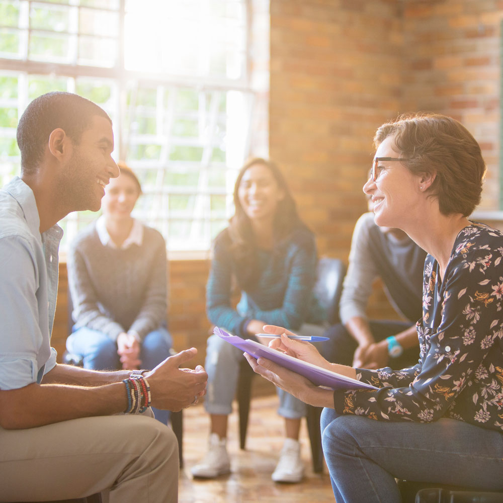 two people talking earnestly at a group therapy session