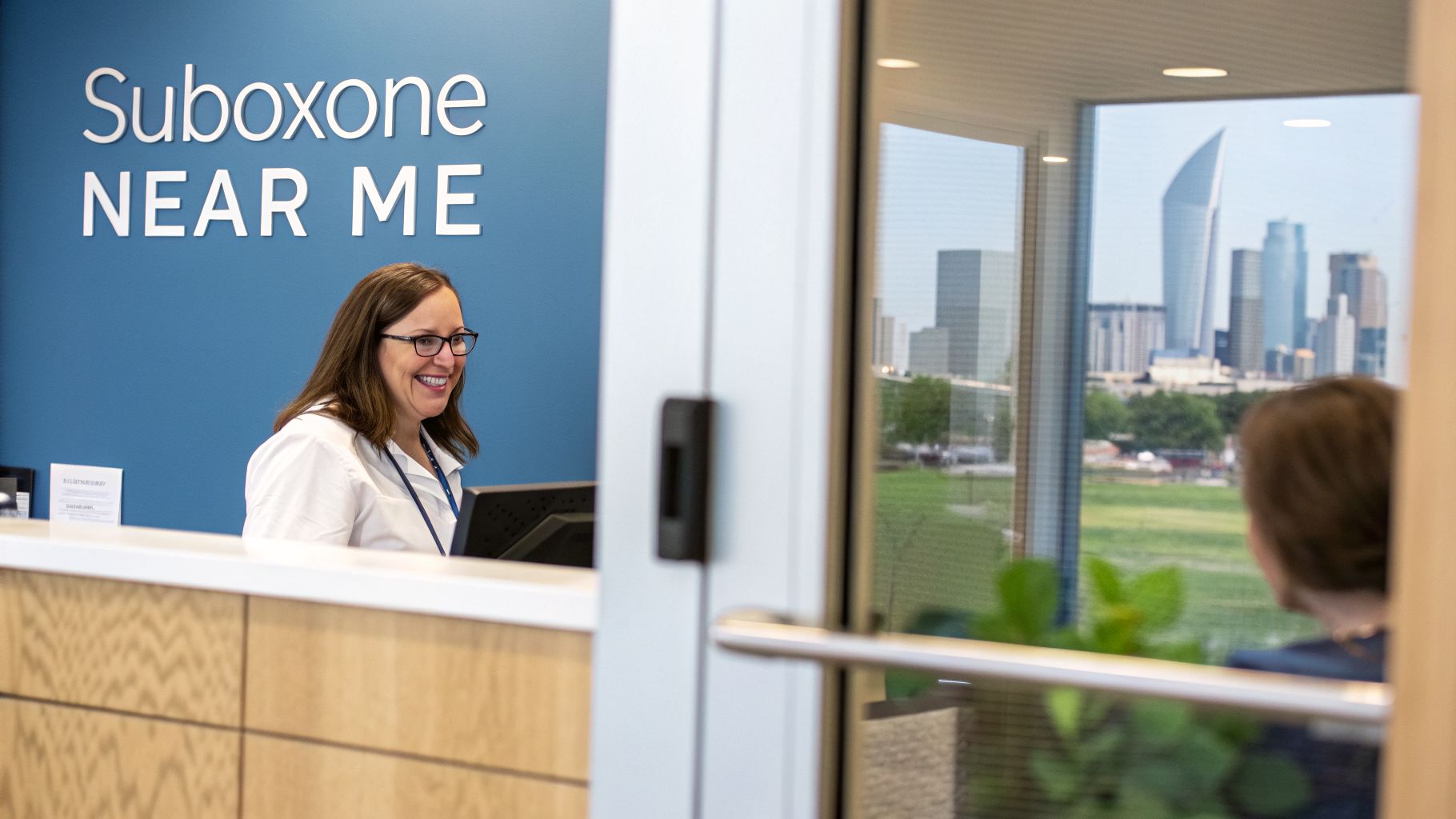 Smiling receptionist behind a desk in a Suboxone clinic, with a city skyline visible through a window.