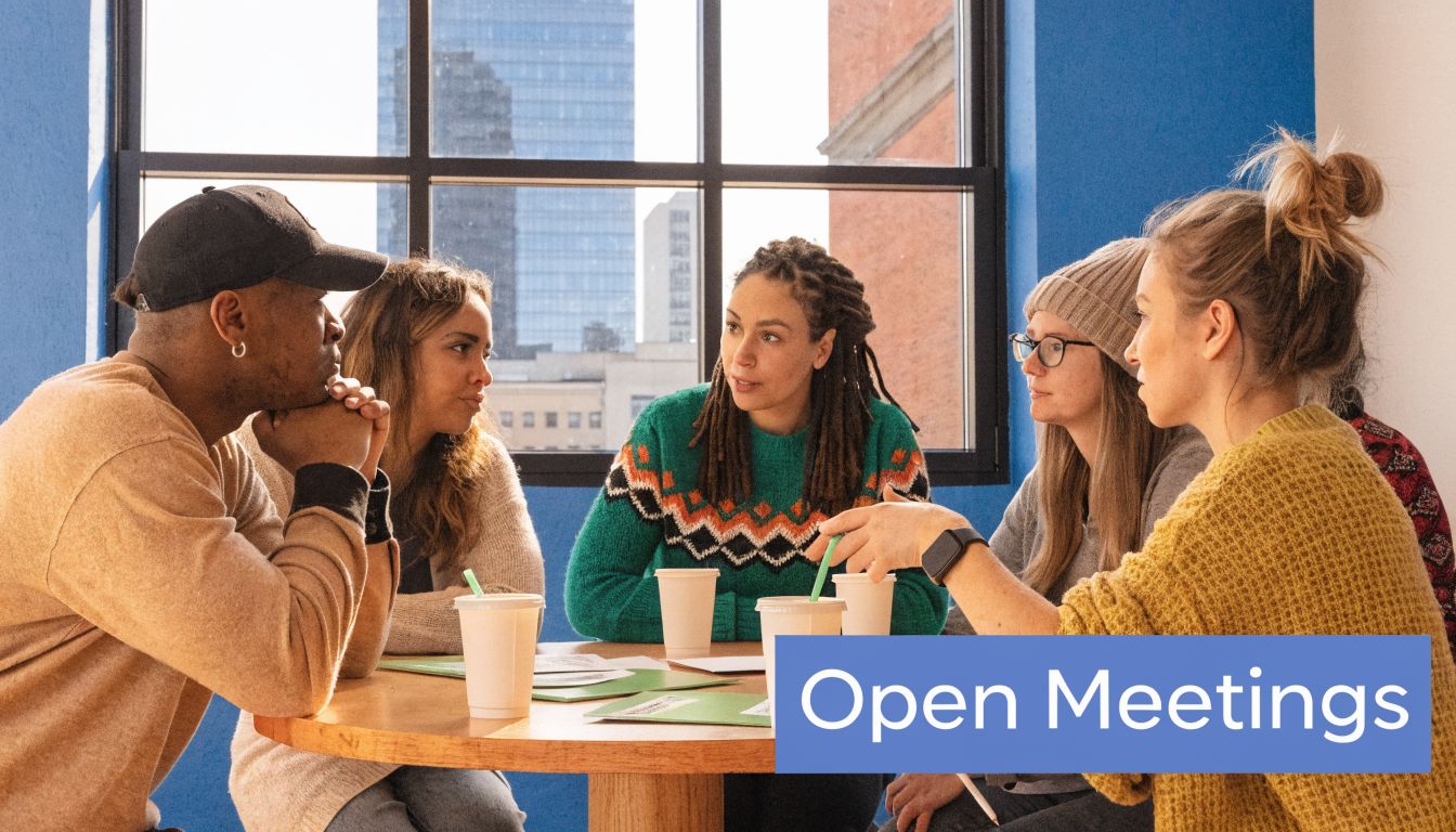 A diverse group of people sitting around a round table engaged in a collaborative open meeting discussion.
