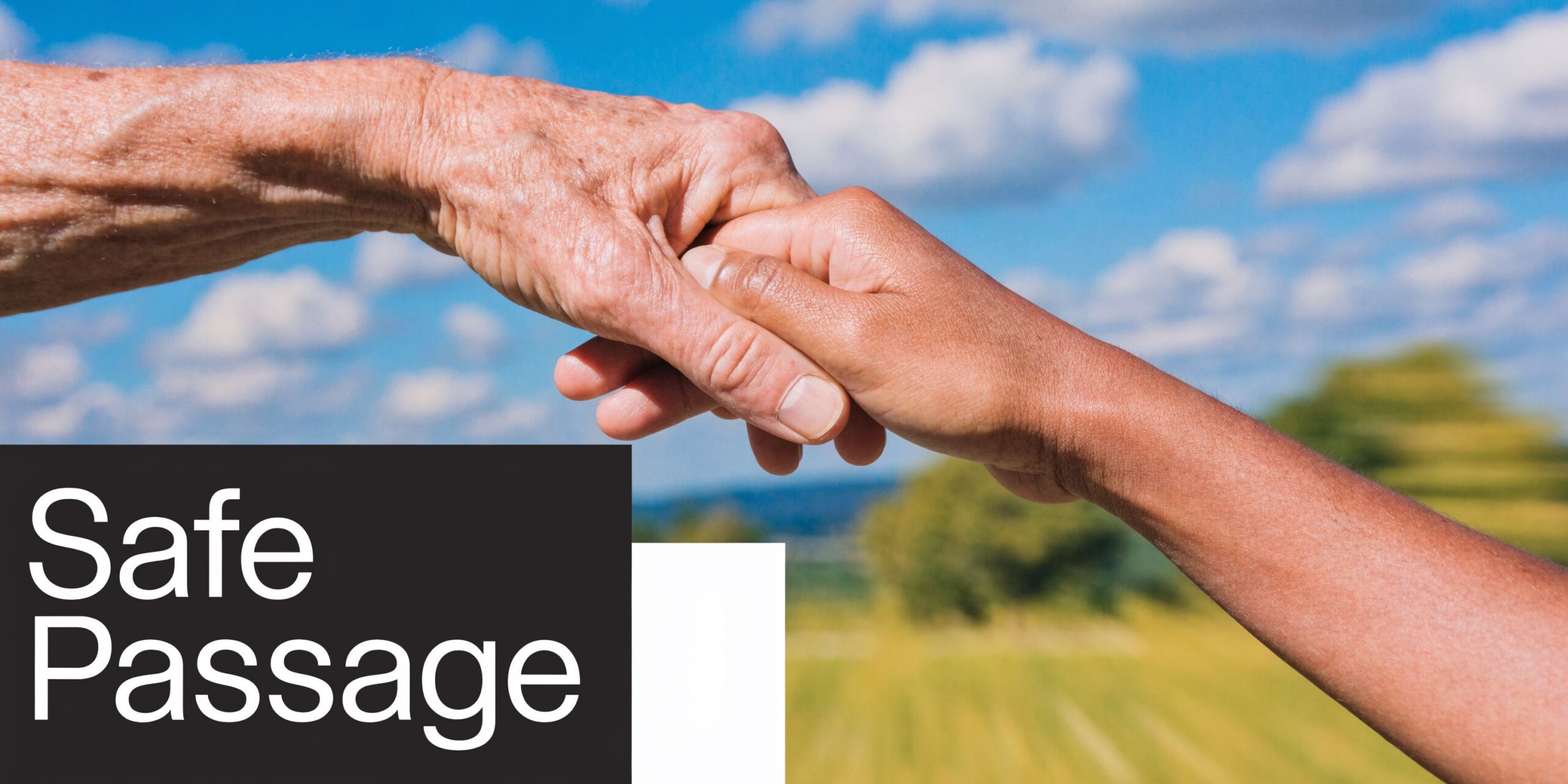 A younger person holds the hand of an elderly person against a sunny blue sky background.