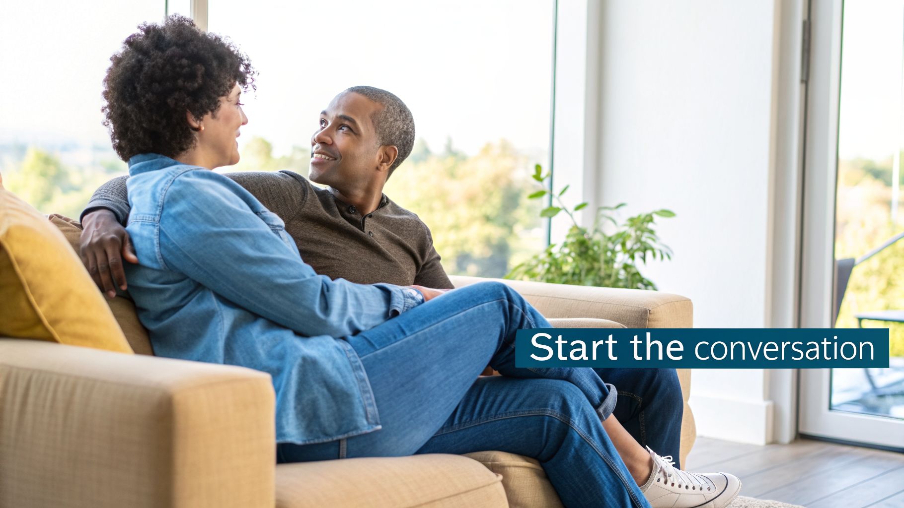 A smiling couple on a couch, looking at each other, with text "Start the conversation".