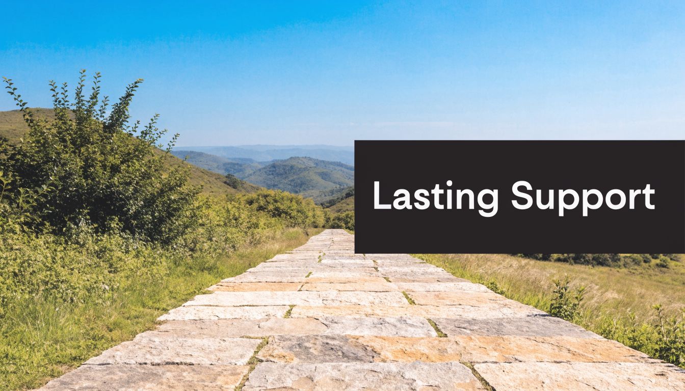 A stone path leading toward rolling green mountains under a clear blue sky with white text overlay.
