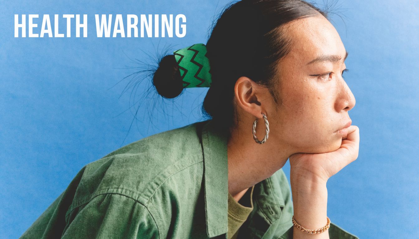 A person with their head resting on their hand, looking to the side against a blue background.