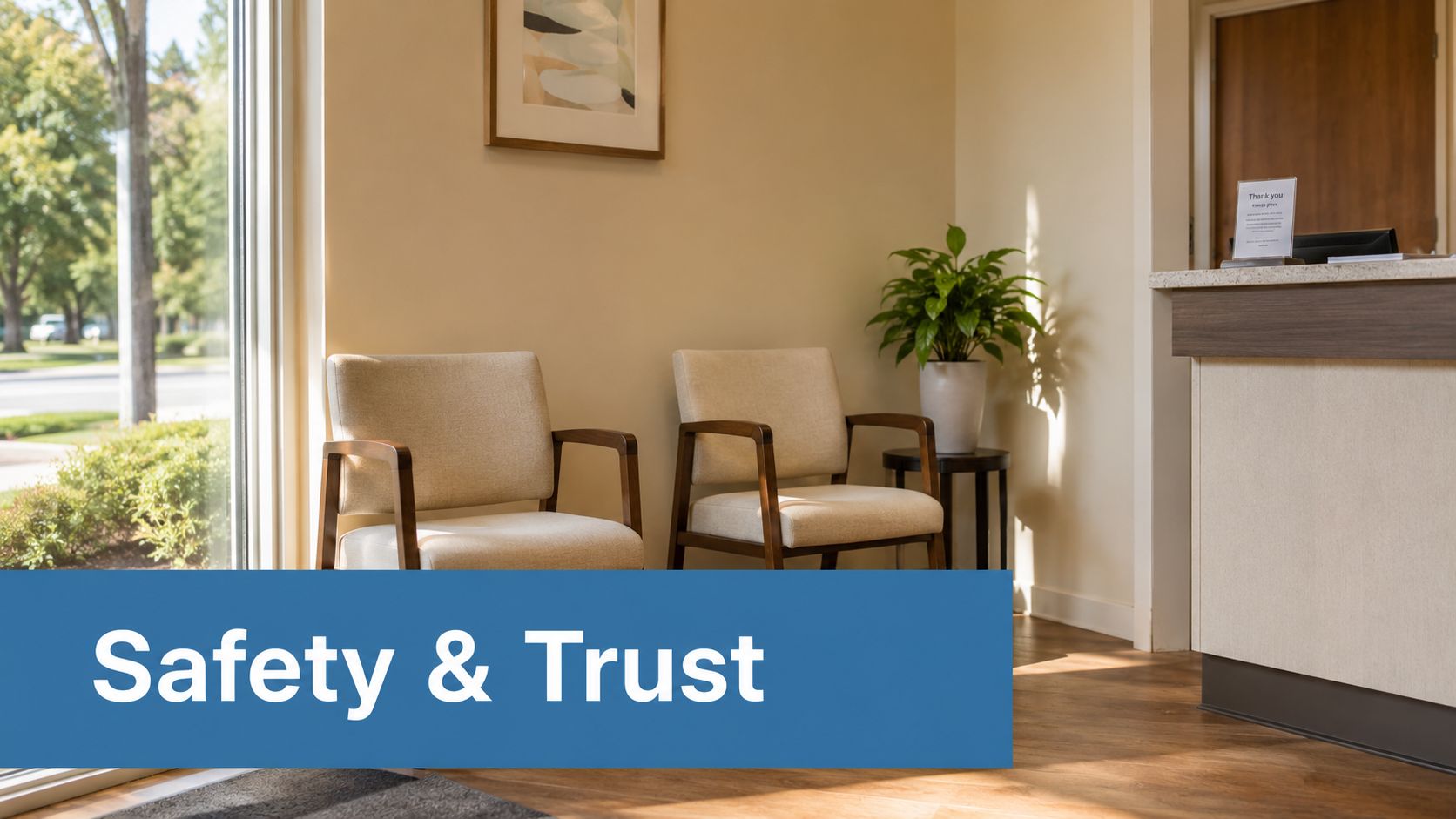 A welcoming waiting room with two comfortable beige chairs and a plant near a reception desk.