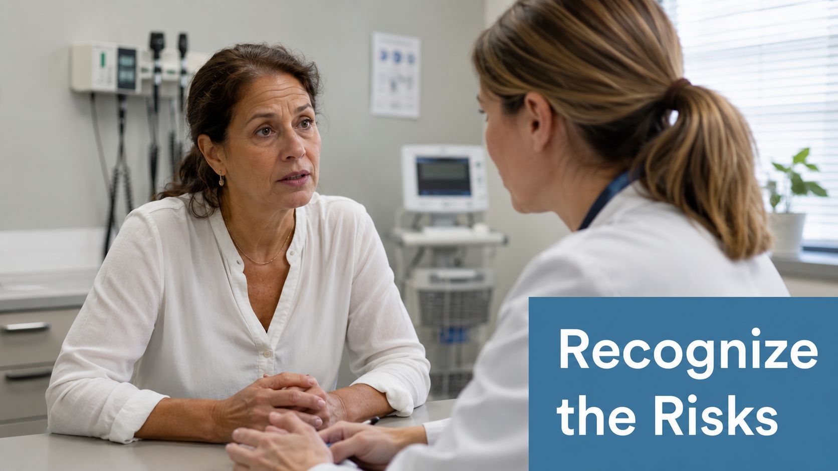 A concerned patient in a white shirt speaking with her female doctor in a medical office.